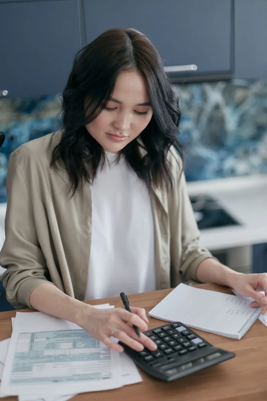 Entrepreneuse qui fait ses comptes avec une calculatrice
